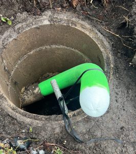 Kaivon toisessa päässä epoksilla kyllästetty uusi putki näkyvillä. Sukan kuivuttua leikataan yli tuleva osuus pois.
